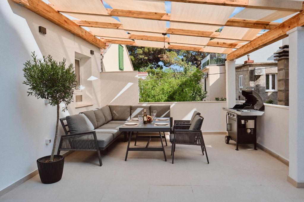 a patio with a couch and a table and chairs at Villa Dora in Omiš centar now with Jacuzzi in Omiš