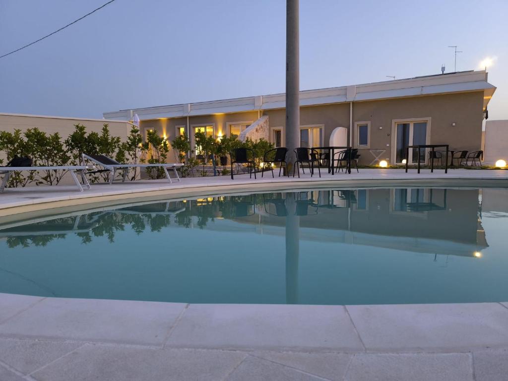 a swimming pool in front of a building at Archè Agriturismo in Gioia del Colle