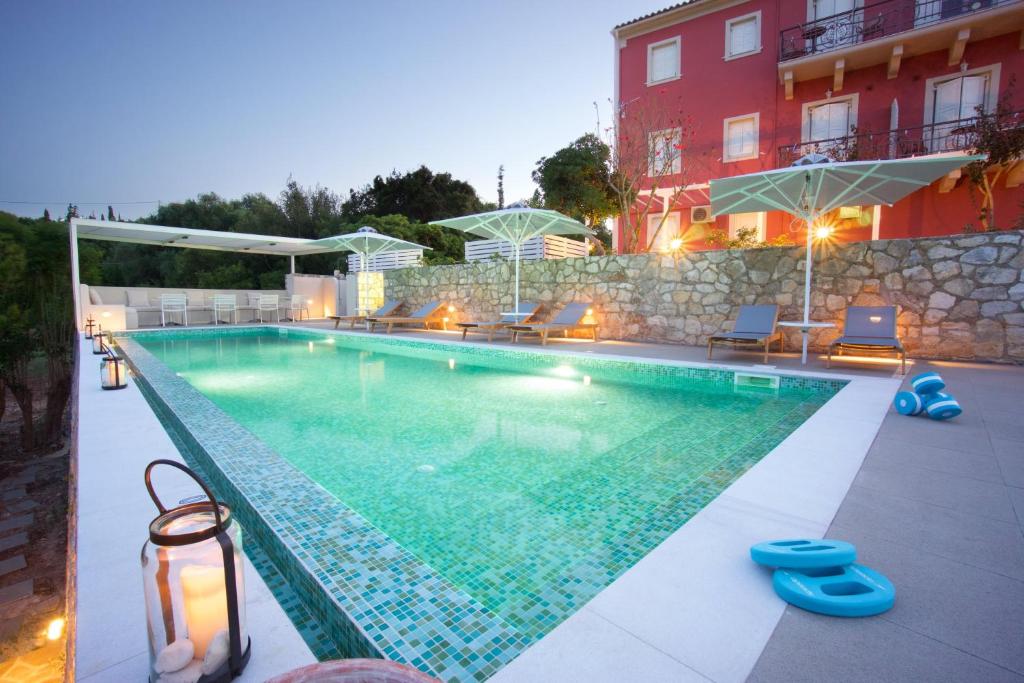 a swimming pool in front of a building at Magnolia Apartments in Fiskardho