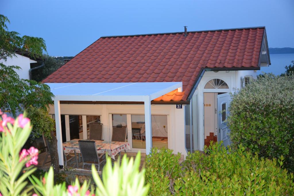 a house with a red roof and a patio at Sunny Cottage in Petrcane