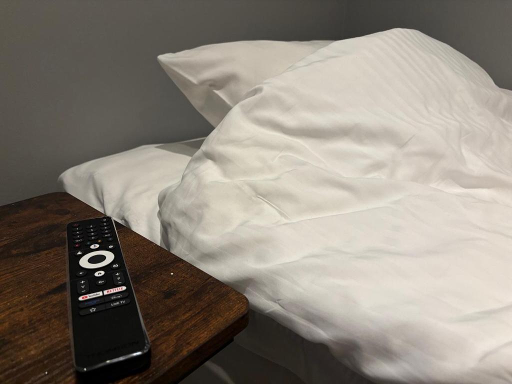 a remote control sitting on a table next to a bed at CityBed Bed & Breakfast in Pajala