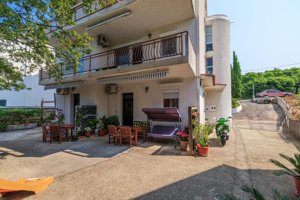 a building with chairs and tables in front of it at Apartment Vlatka Grof in Selce