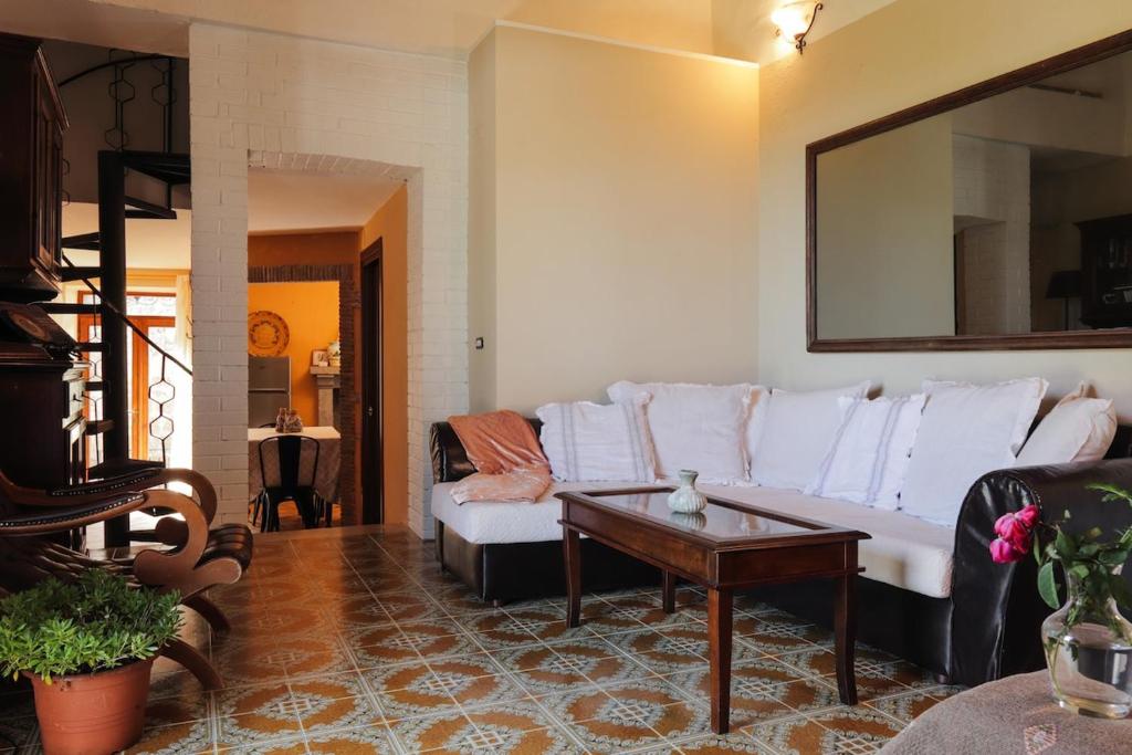Una sala de estar con un sofá blanco y una mesa. en Casa Erica, en Lubriano