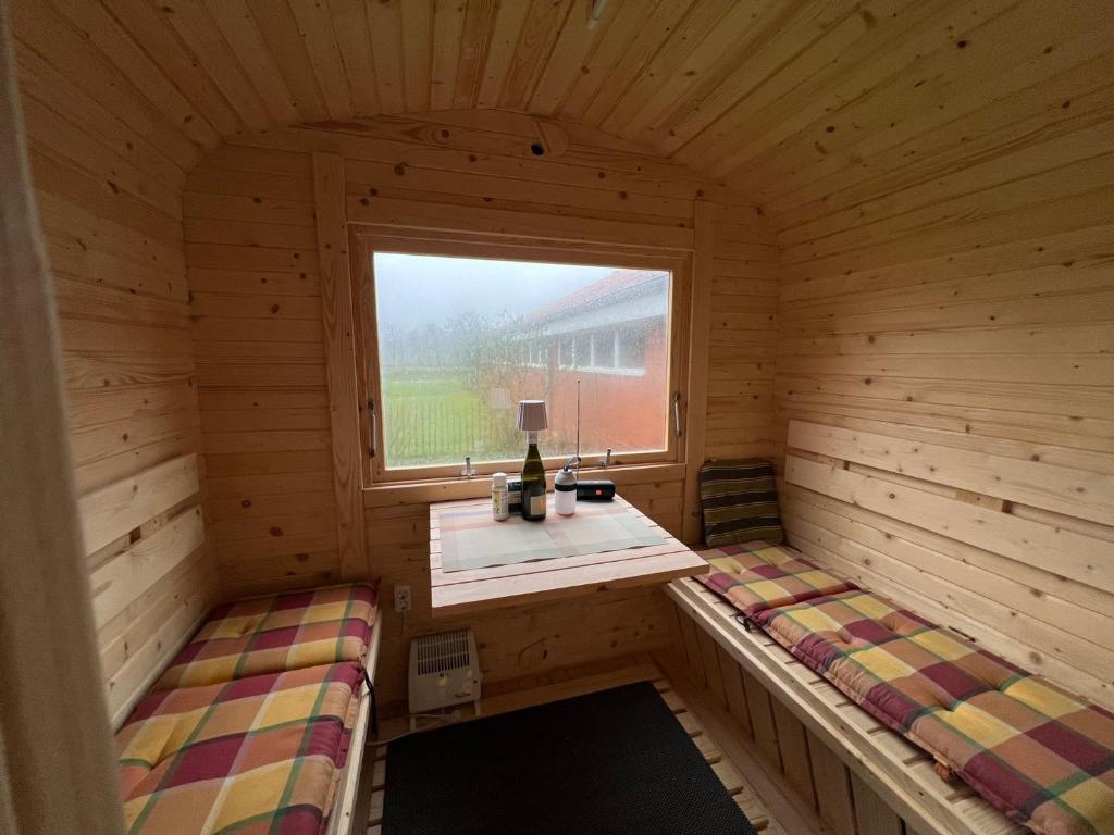 a room with two beds in a wooden room with a window at Ferienhaus Gulfhof Tjaden in Großefehn 