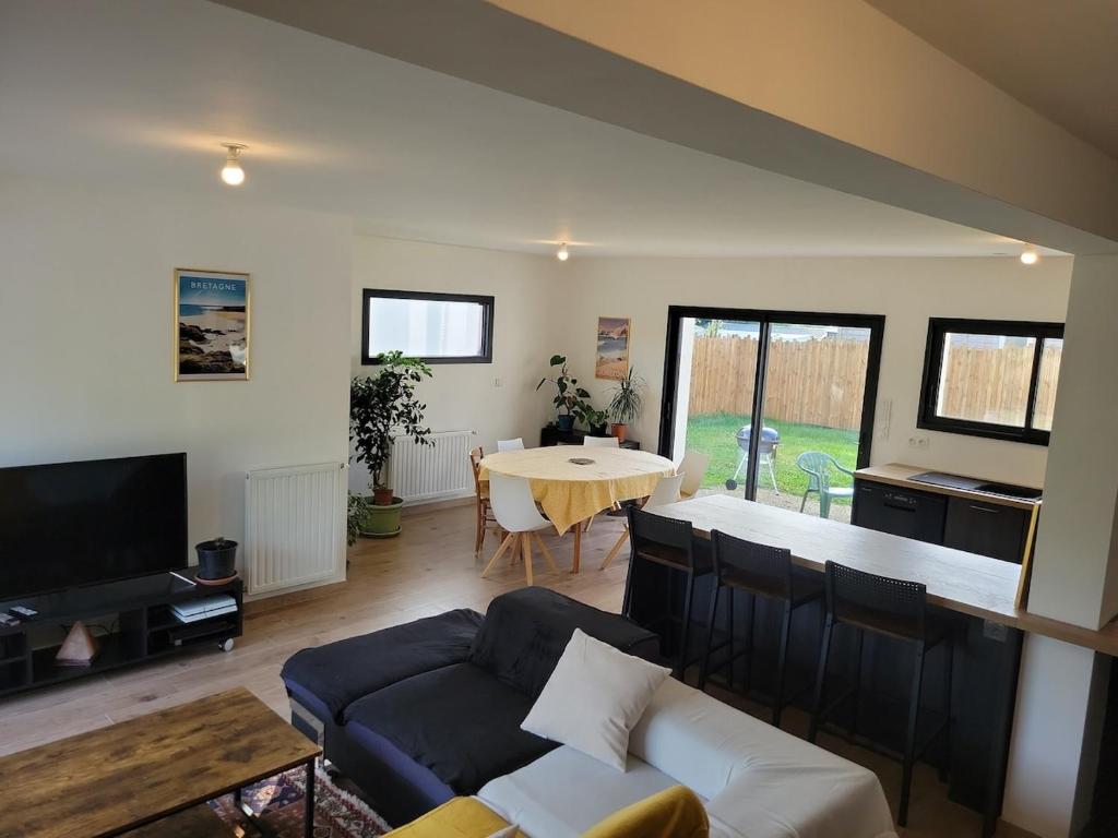 a living room with a couch and a table at Maison Saint Philibert 3 chambres in Saint-Philibert