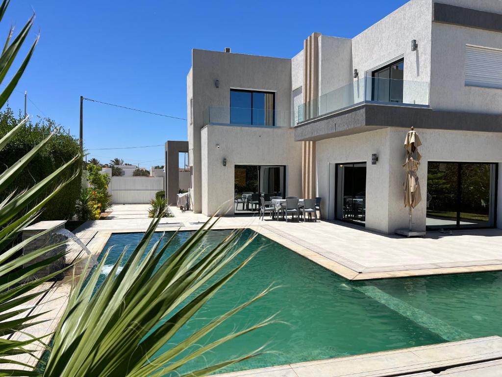 Villa Nour في تاجورميس: منزل مع حوض سباحة أمامه