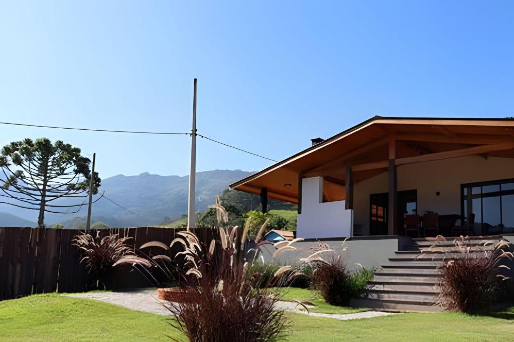 una casa con una valla y escaleras en un patio en Casa Tempo | 2h30 SP | Exclusividade na montanha, en Santo Antônio do Pinhal