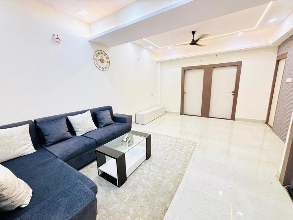 a living room with a blue couch and a table at Varanasi Nest in Varanasi