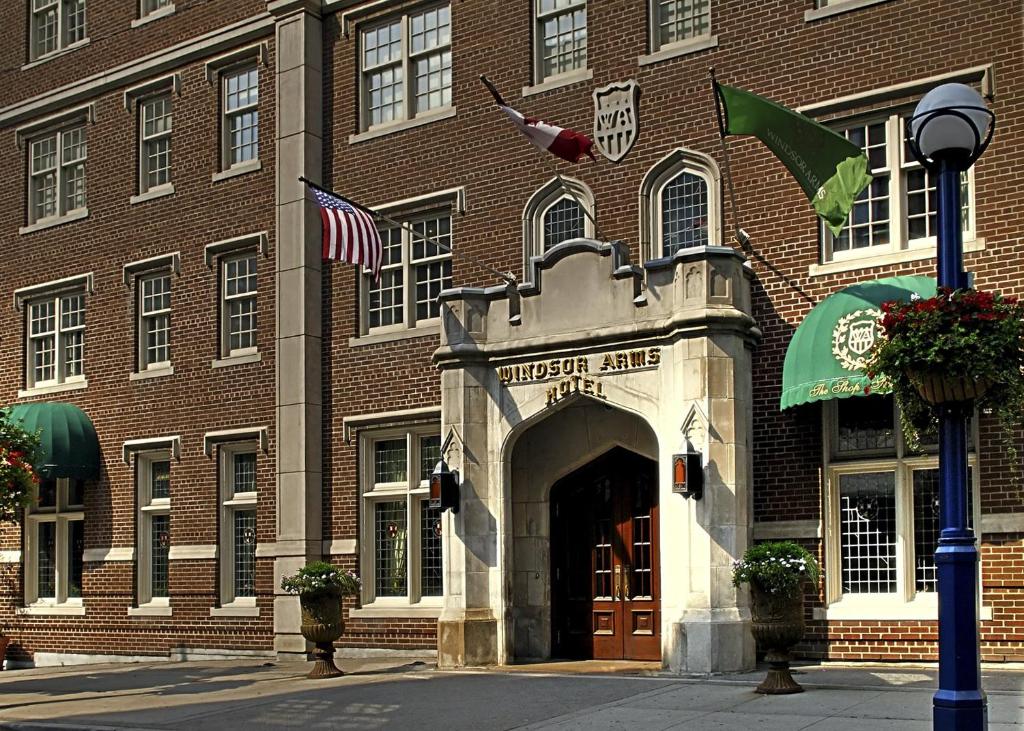 un edificio de ladrillo con una bandera americana delante de él en Windsor Arms Hotel, en Toronto