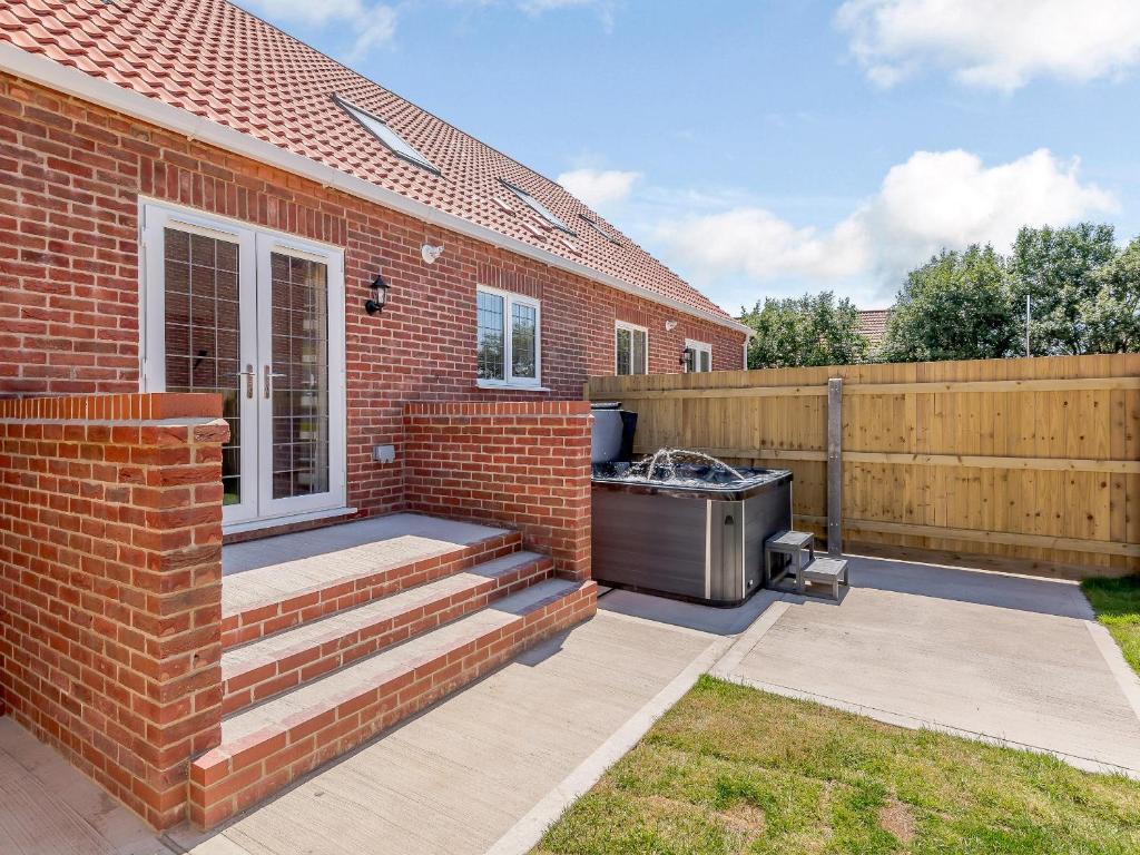 a barbecue on a patio next to a brick house at Dawson Park 6 - Uk12665 in Mablethorpe