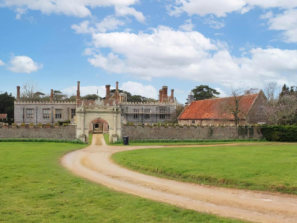 an old building with a dirt road in front of it at The Barn in Hunstanton