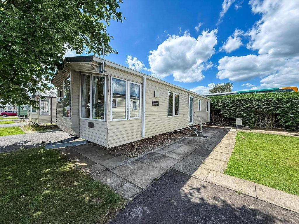 a tiny house is sitting in a yard at Homely 6 Berth Caravan At Southview Holiday Park, Lincolnshire Ref 33010M in Skegness