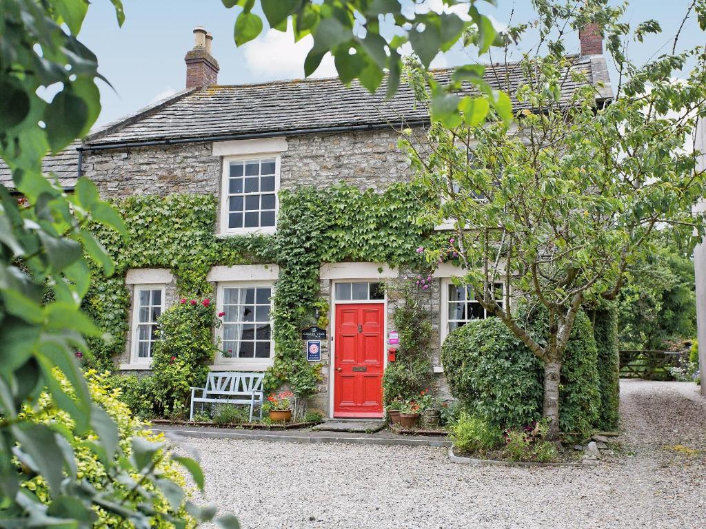 a brick house with a red door at Cherry Tree Cottage in Bellerby