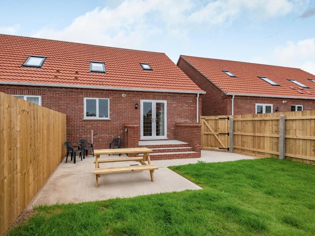 a house with a wooden fence and a wooden bench at Dawson Park 7 - Uk12666 in Mablethorpe