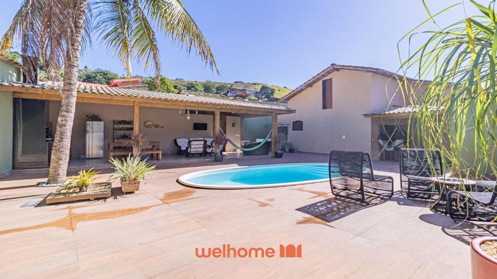 a backyard with a pool and a house at Casa em Paraty com piscina e churrasqueira in Paraty