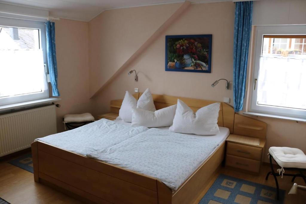 a bedroom with a bed with white sheets and pillows at Haus Budinger in Alf