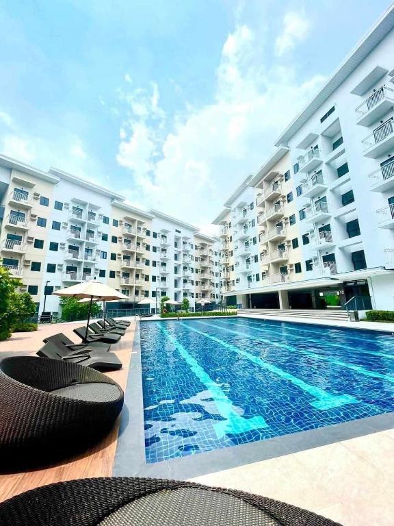 a swimming pool in front of a large apartment building at Hills Staycation by SDC in Manila