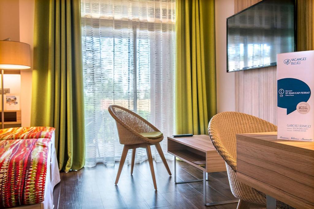 a room with two chairs and a table and a window at Hôtel Vacances Bleues Delcloy in Saint-Jean-Cap-Ferrat