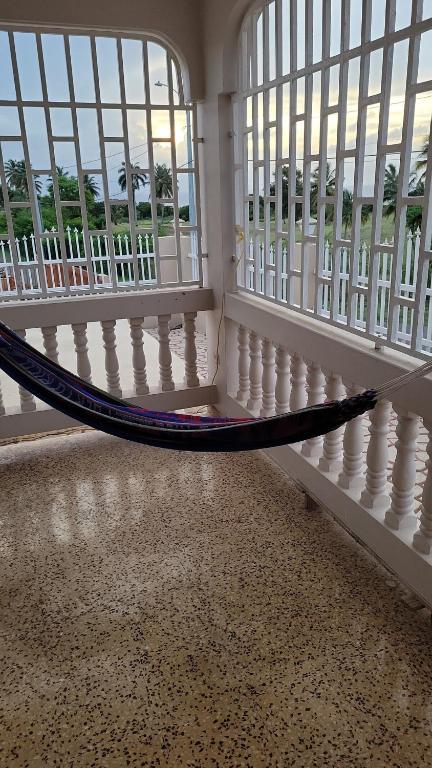 a room with a hammock in a room with windows at Besos del Mar Ocean and Golf course view in Aguadilla