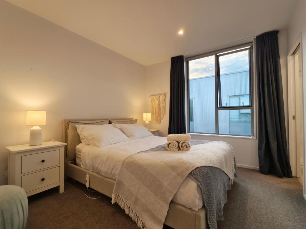 a bedroom with a bed and a large window at Walk to Stadium CBD 2BR 2Bath Free Reserved Parking - JJHome in Christchurch
