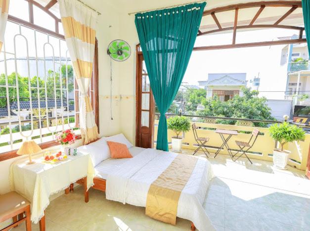 a bedroom with a bed and a large window at Hotel Ngọc My in Phan Thiet