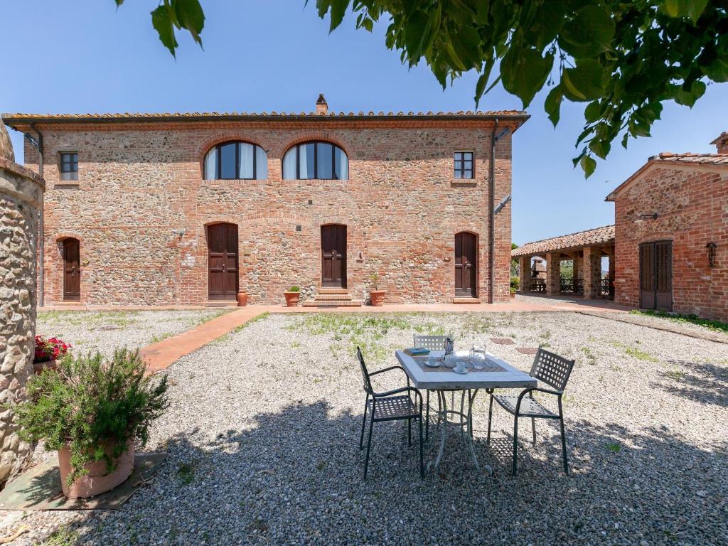 a table and chairs in front of a brick building at Peccioli Family Retreat w Fun in Peccioli