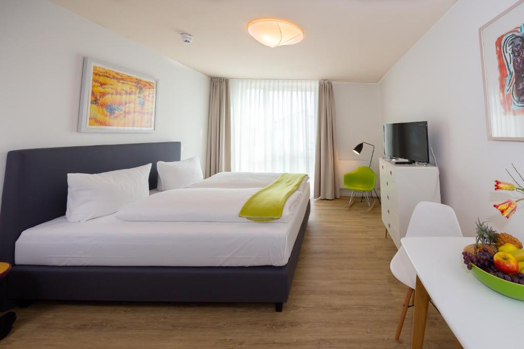 a hotel room with a bed and a table with a television at Country Inn Suitenhotel in Werder