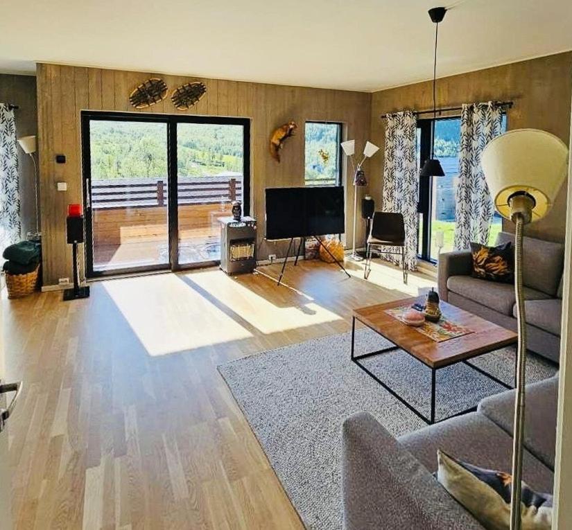 ein Wohnzimmer mit Sofa und Tisch in der Unterkunft Mountain Apartment With Views In Myrkdalen in Vossestrand