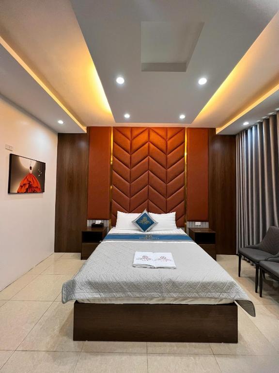 a bedroom with a bed with a wooden headboard at Ruby 3 Hotel in Hanoi