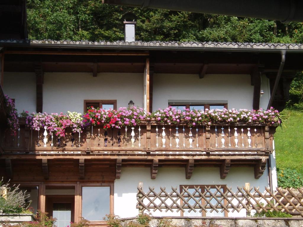 ein Gebäude mit einem Balkon voller Blumen in der Unterkunft Ferienwohnung Wörndl in Faistenau