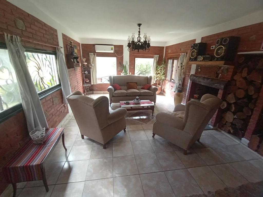 a living room with a couch and chairs and a fireplace at Casa familiar de Campo Arev in Las Rabonas