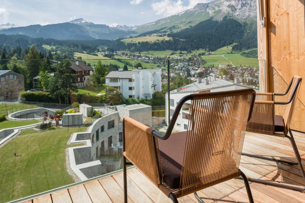 a chair on a balcony with a view of mountains at Edelweiss Mountain Suites 07-06 in Flims