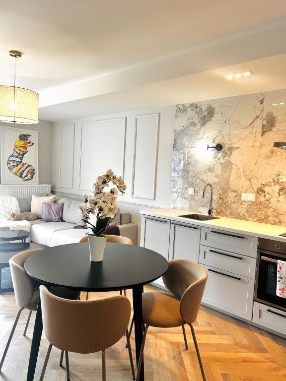 a kitchen and living room with a table and chairs at Downtown Apartments Podpromie Monica with UNDERGROUND PARKING in Rzeszów