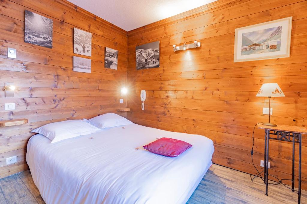 a bedroom with a white bed and wooden walls at Les Glières - Champagny-en-Vanoise in Champagny-en-Vanoise