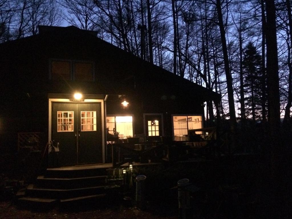 una casa con una luz en la parte delantera de la noche en Lodge Stack Point, en Narusawa