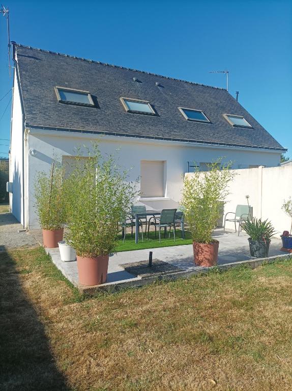 une maison avec des plantes en pot devant dans l'établissement GRAND GITE MER ET CAMPAGNE AVEC DEUX LOGEMENTS INDEPENDANTS COMMUNIQUANTS 6 chambres 4 salles de bains, à Férel