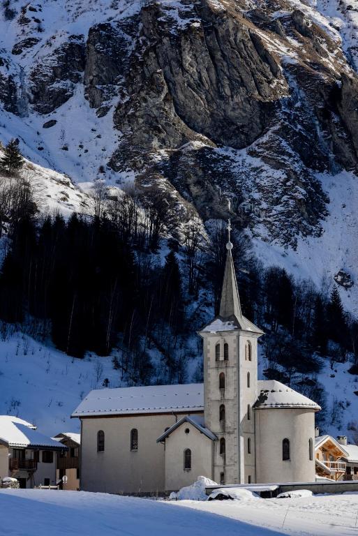 a church with a snow covered mountain in the background at Les Glières - Champagny-en-Vanoise in Champagny-en-Vanoise