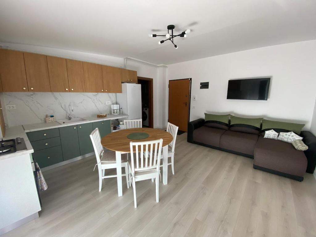 a kitchen and living room with a table and chairs at Home Away Bistrița in Bistriţa