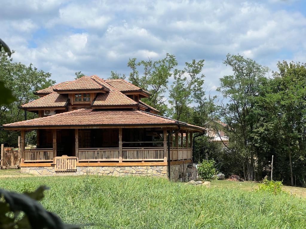 a large house with a tiled roof in a field at Brvnara "Duboki Potok" in Vrnjačka Banja