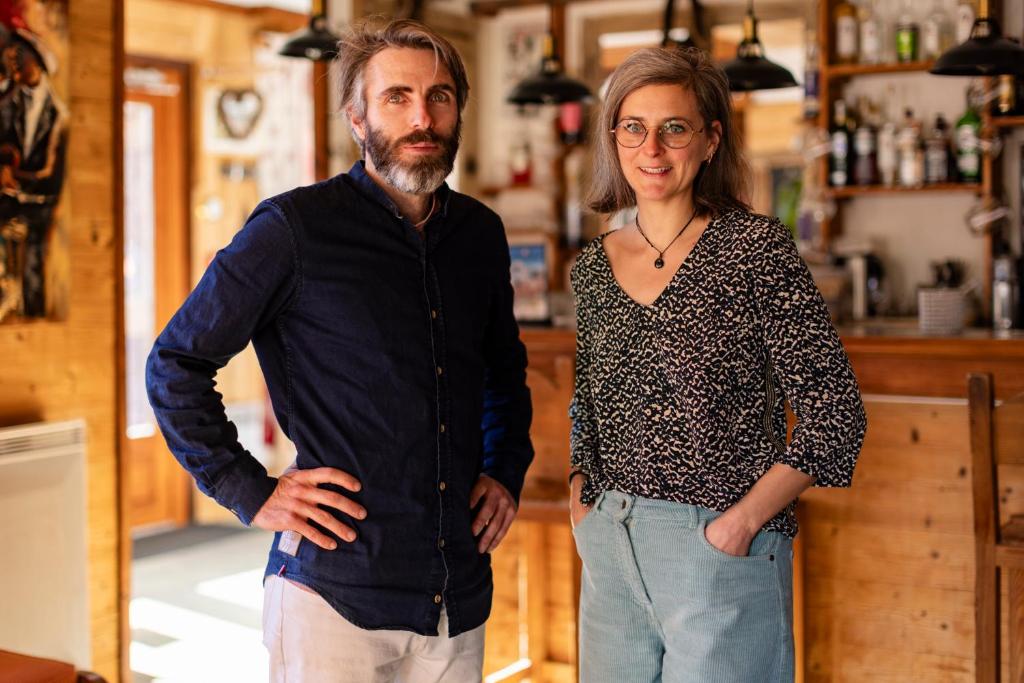 a man and a woman standing in front of a bar at Les Glières - Champagny-en-Vanoise in Champagny-en-Vanoise