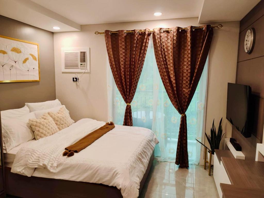 a bedroom with a bed and a large window at Maison De Tabasa near Tops Cebu in Cebu City