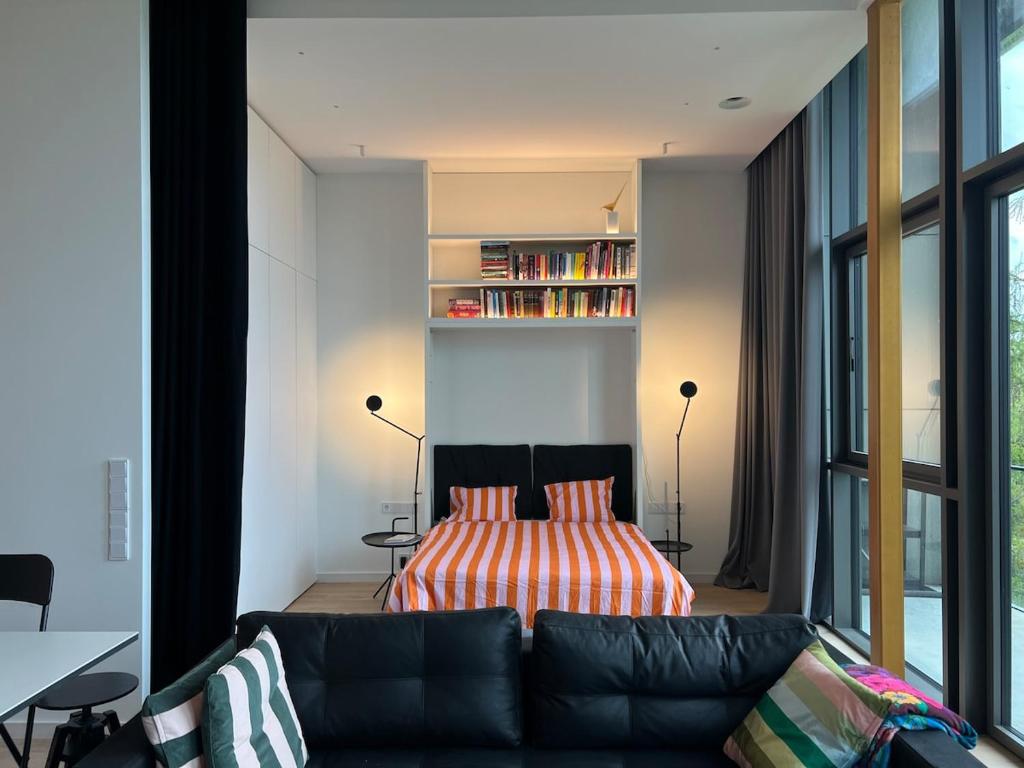 un soggiorno con divano e letto di Design apartment with view to Nemunas, Prienai a Pakopi