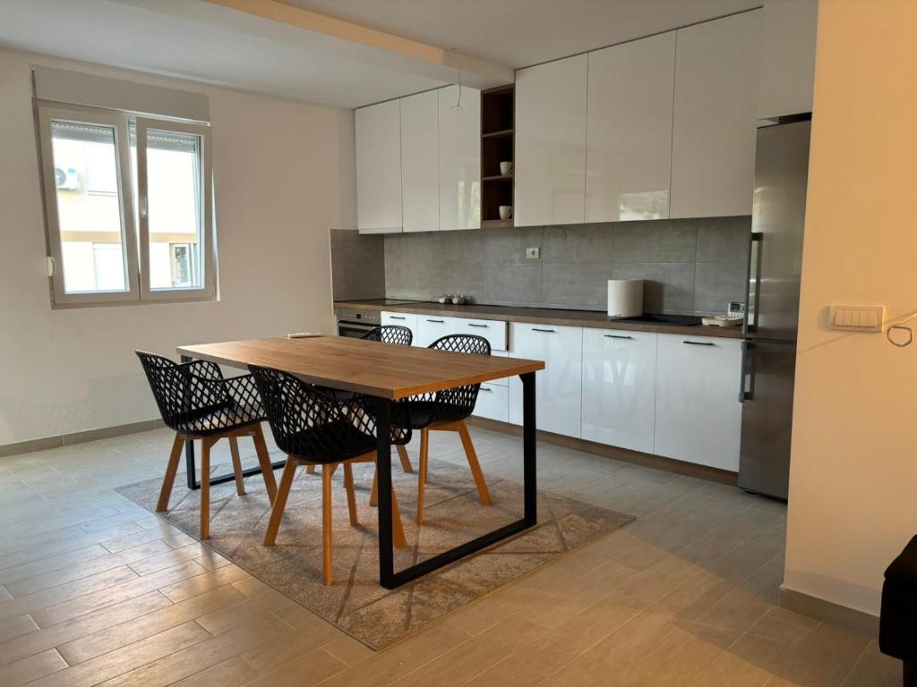 Una cocina con una mesa y sillas de madera. en Zemun ES stan na dan, en Belgrado