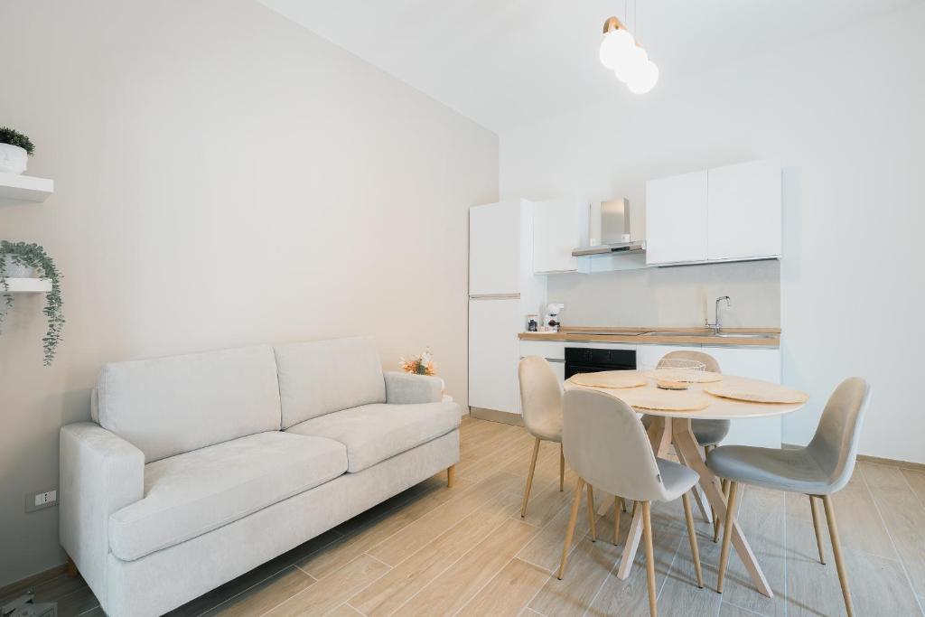 a living room with a white couch and a table at Dimora Pacinotti in Olbia