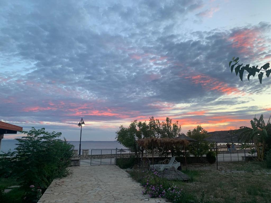 a sunset over the ocean with a cloudy sky at White Marine Hotel in Qeparo