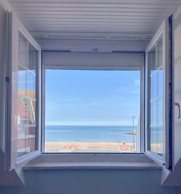 a large window with a view of the ocean at L'Heurt Bleue - Maison de pêcheur face mer in Le Portel