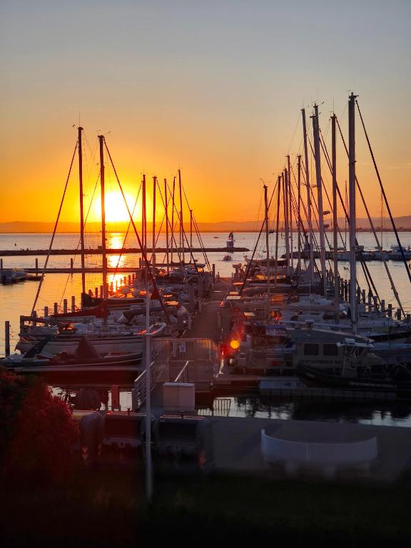 un groupe de bateaux amarrés dans une marina au coucher du soleil dans l'établissement Adoya plage Studio cabine vue port et mer, au Grau-du-Roi
