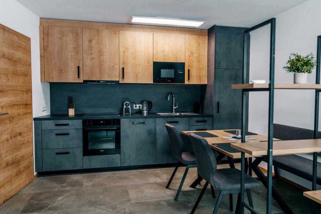 a kitchen with wooden cabinets and a table with chairs at Danner Appartements Wolfsegg am Hausruck- Ferienwohnung & Business-Appartements Ruhige Lage, moderne Ausstattung, faire Preise in Wolfsegg am Hausruck