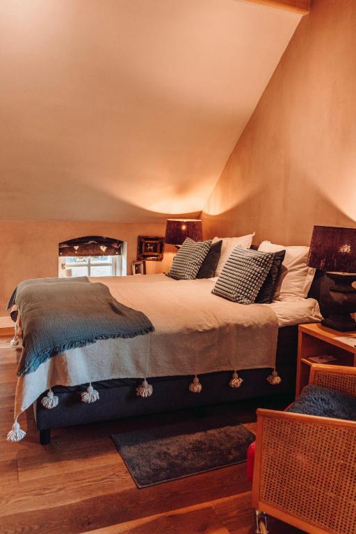 a bedroom with a large bed with pillows on it at Bedandbreakfast De Vallei in Heelsum