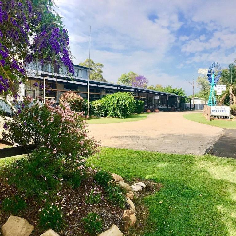 a building with purple flowers in front of it at Cattle Camp Motel in Taroom